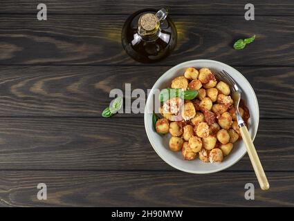 Gnocchi di patate tradizionali con salsa di pomodoro e formaggio su un piatto bianco. Foto Stock