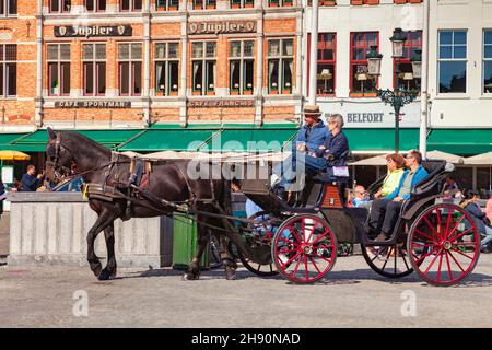 25 settembre 2018: Bruges, Belgio, turisti che cavalcano a cavallo e in carrozza in una strada cittadina. Foto Stock