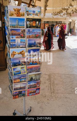Una rastrelliera di cartoline all'esterno di un negozio di souvenir al Seef, Dubai Foto Stock