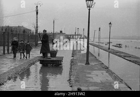 Warszawa, 1947-03. Stacja kolejki jab³onowskiej (karczewskiej) Warszawa Most, w pobli¿u dawnego mostu Kierbedzia, zalana przez rzekê Wis³ê. NZ. Kolejarz przemieszcza siê na ma³ej platformie. W tle przês³o zerwanego przez krê mostu Wysokowodnego. wb PAP Dok³adny dzieñ wydarzenia nieustalony. Varsavia, marzo 1947. La stazione di Varsavia più della ferrovia a scartamento ridotto jablonowska (karczewska), nelle vicinanze dell'ex ponte di Kierbedzia, inondato dal fiume Vistula. Nella foto: Un vagone ferroviario che si ricolloca su una piccola piattaforma. Sullo sfondo il tratto del ponte danneggiato dal ghiaccio galleggia. wb PAP Foto Stock