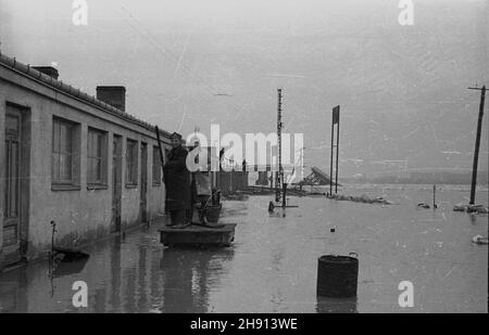 Warszawa, 1947-03. Po³udniowa czêœæ stacji kolejki jab³onowskiej (karczewskiej) Warszawa Most, w pobli¿u dawnego mostu Kierbedzia, zalana przez Wis³ê. NZ. Kolejarz przemieszcza siê na ma³ej platformie. W tle przês³o zerwanego przez krê mostu Wysokowodnego. wb PAP Dok³adny dzieñ wydarzenia nieustalony. Varsavia, marzo 1947. La parte meridionale della stazione più vicina di Varsavia della ferrovia a scartamento ridotto jablonowska (karczewska), nelle vicinanze dell'ex ponte di Kierbedzia, inondato dal fiume Vistula. Nella foto: Un vagone ferroviario che si ricolloca su una piccola piattaforma. Sullo sfondo la campata del ponte Foto Stock