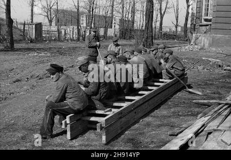 Warszawa, 1947-03. Jeñcy niemieccy porz¹dkuj¹ teren wokó³ Instytutu Geologicznego przy ul. Rakowieckiej. NZ. Przerwa na posi³ek. W tle gmach Urzêdu Patentowego i Centralnego Zarz¹du Energetyki. wb PAP Dok³adny dzieñ wydarzenia nieustalony. Varsavia, marzo 1947. Prigionieri di guerra tedeschi che fanno lavori di manutenzione intorno all'Istituto Geologico in via Rakowiecka. Nella foto: Una pausa per un pasto. Sullo sfondo la costruzione dell'Ufficio brevetti e della Power Industry Central Management. wb PAP Foto Stock