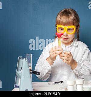 Ragazza sorridente che fa un esperimento di scienza per la scuola Foto Stock