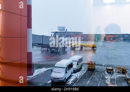 Mosca. Russia. 12/20/2020. Manutenzione degli aeromobili all'aeroporto di Sheremetyevo. Aeroflot. Ural Airlines. Vista attraverso il vetro dell'aeroporto con riflessi Foto Stock