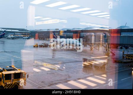 Mosca. Russia. 12/20/2020. Manutenzione degli aeromobili all'aeroporto di Sheremetyevo. Aeroflot. Ural Airlines. Vista attraverso il vetro dell'aeroporto con riflessi Foto Stock