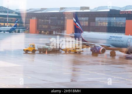 Mosca. Russia. 12/20/2020. Manutenzione degli aeromobili all'aeroporto di Sheremetyevo. Aeroflot. Ural Airlines. Vista attraverso il vetro dell'aeroporto con riflessi Foto Stock