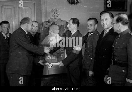 Warszawa, 1947-04. Wizyta delegacji Ochotniczej Rezerwy Milicji Obywatelskiej (ORMO) z powiatu Lubañ w województwie wroc³awskim u W³adys³awa Gomu³ki ministra Ziem Odzyskanych. W trakcie spotkania zosta³a wrêczona wicepremierowi tablica pami¹tkowa z jego podobizn¹ wykonana przez artystê samouka, ormowca z pow. Lubañ. NZ. Porucznik Stolarski wrêcza dar ministerowi Gomu³ce. Pierwszy z prawej gen. Franciszek JóŸwiak (pseudo gen. Witold) komendant g³ówny Milicji Obywatelskiej. uu PAP/Stanis³aw D¹browiecki Dok³adny dzieñ wydarzenia nieustalony. Varsavia, aprile 1947. La visita di una delgazione di Foto Stock