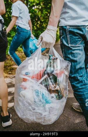 Ambientalisti maschili e femminili che puliscono i rifiuti nel parco Foto Stock
