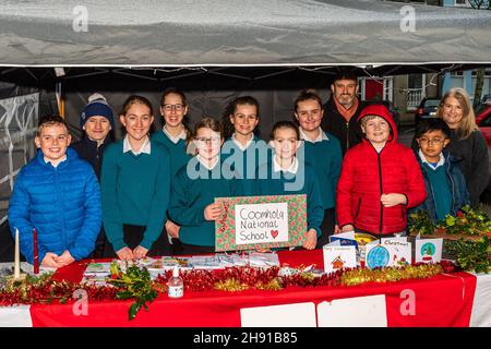 Bantry, West Cork, Irlanda. 3 dicembre 2021. Bantry Farmers Market ha assunto una curva di Natale oggi. Alunni e insegnanti della Coomhola National School erano al mercato che vendevano carte di Natale fatte a mano, candele e corone in aiuto delle felpe di Natale di sesta classe. Una donazione deve essere fatta alle associazioni di beneficenza locali a partire dai proventi. L'insegnante Tom Farmey e SNA Deirdre Kingston sono raffigurati con gli allievi. Credit: AG News/Alamy Live News Foto Stock