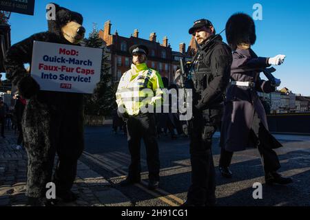 Windsor, Regno Unito. 2 dicembre 2021. L'orso DI PETA è raffigurato durante la cerimonia del cambio della Guardia all'esterno del Castello di Windsor come parte di una campagna volta a sollecitare il Ministero della Difesa a far cadere l'uso di veri cappelli in pelle d'orso. Il mese scorso, PETA e Faux furrier di lusso ECOPEL hanno rivelato la prima pelliccia di orso ausiliario del mondo, che appare e funziona come la pelle del bearskin usata per fare la protezione della Regina. PETA dichiara che prende la pelle di almeno un orso per fare ogni cappuccio e ECOPEL ha offerto di fornire il mod con pelliccia di orso faux gratuitamente fino al 2030. Credit: Mark Kerrison/Alamy Live News Foto Stock