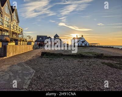 Il sole tramonta dietro il pub Old Neptune sulla spiaggia di Whitstable alla fine di una bella giornata Foto Stock