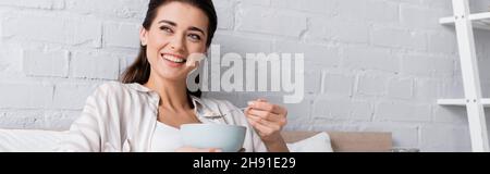 donna felice che tiene ciotola con farinata d'avena, striscione Foto Stock