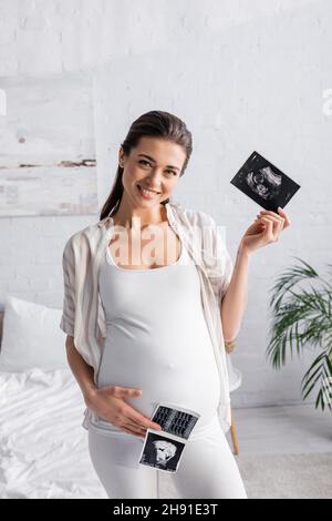 donna in stato positivo e in stato di gravidanza che esegue scansioni ecografiche Foto Stock