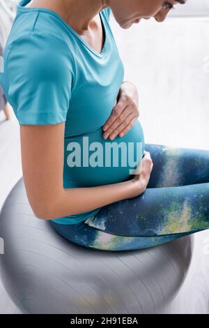allegro sportivo incinta che si esercita sulla palla fitness Foto Stock