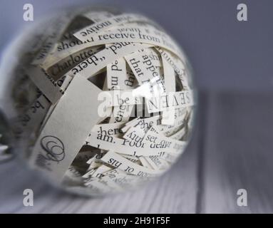 Bauble di Natale con le strisce tagliate del Pride di Jane Austen e romanzo di pregiudizio all'interno Foto Stock