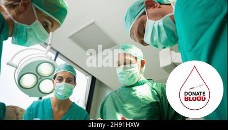 Composito digitale di donare il simbolo del sangue sul team chirurgo in pronto soccorso in ospedale Foto Stock
