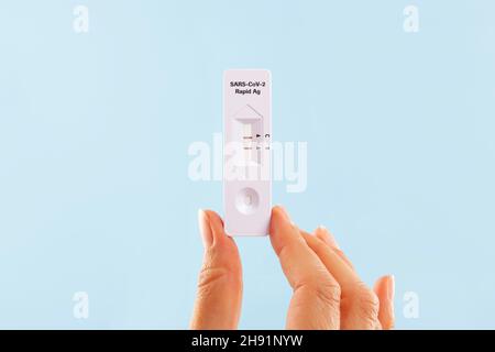 Donna che tiene in mano il test dell'antigene rapido Sars-cov-2 positivo. Foto Stock