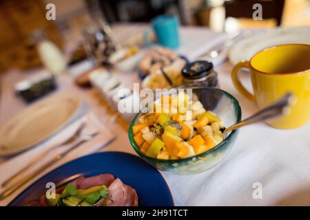 Tavolo ben posato con cibi biologici fatti in casa e prelibatezze per il brunch domenicale nel soggiorno di casa Foto Stock