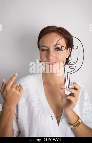 punto di domanda in mano di una giovane donna pensiva in indecisione della scelta giusta. Dubbio, sfida, riflessione, concetto ponderante Foto Stock