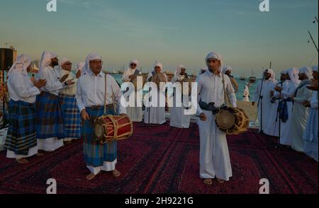 Danza folcloristica tradizionale del Qatar (danza Ardah) a Katara undicesimo festival dhow tradizionale a Doha Qatar tramonto sparato Foto Stock