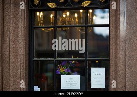 Fiori e avvisi che informano i clienti della data di riapertura e delle istruzioni sulle misure sanitarie sono visibili nella finestra di un pub di Londra. Foto Stock