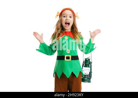 Ragazzina eccitata vestita come gnome divertente o elfo in posa isolata su sfondo bianco studio. Inverno, vacanza, natale concetto Foto Stock