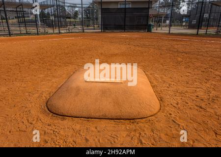 In piedi di fronte a un tumulo di caraffe che guarda verso la base di casa in un campo da baseball in un parco vuoto nella prima primavera closeup vista Foto Stock