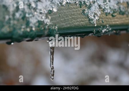 Monaco di Baviera, Germania. 03 dicembre 2021. Un icicle è appeso al retro di una panca di parco. Credit: Katrin Requadt/dpa/Alamy Live News Foto Stock
