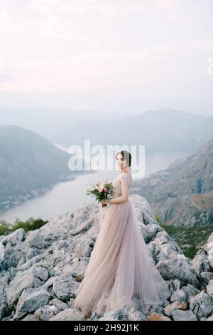 La sposa sorge su una montagna rocciosa sullo sfondo della Baia di Cattaro Foto Stock