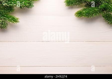 Albero di Natale rami su un fondo di legno chiaro. Nuovo anno e sfondo di Natale. Spazio per il testo Foto Stock