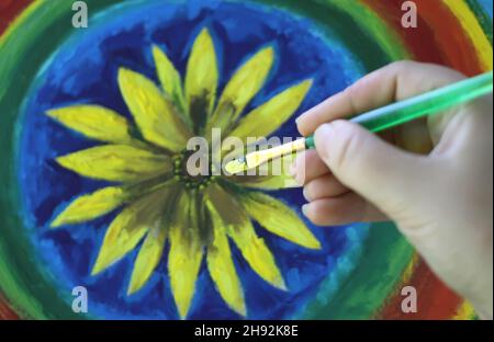 Processo di verniciatura a olio su tela. Una mano con spazzola. Foto Stock