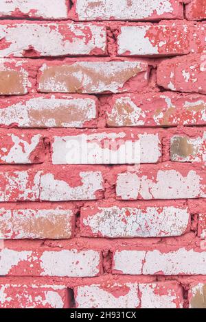 Parete verticale bianca sporca di mattoni con vecchio peeling rosa o vernice rossa intemperie sfondo texture pietra superficie. Foto Stock