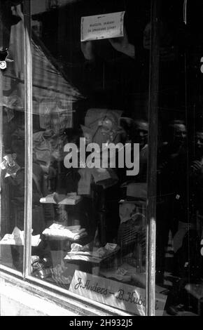 Warszawa, 1947-05-27. Komisja Specjalna do Walki z Nadu¿yciami i Szkodnittem Gospodarczym prowadzi³a dzia³ania przeciwko prywatnym przedsiêbiorcom i w³aœcicielom zwan¹ bitw¹ o handel. akcja spo³ecznych kontrolerów Komisji przeciwko prywatnym us³ugom. Na szybie sklepu z konfekcj¹ kontroler umieszcza wywieszkê: w³aœciciel sklepu ukarany za uprawianie lichwy. ps/ms PAP Varsavia, 27 maggio 1947. La commissione speciale per la lotta contro le frodi e gli utili ha scatenato una guerra contro gli imprenditori e i proprietari privati chiamata guerra al commercio. Nella foto: Ispettori sociali contro i servizi privati. Un'ispirazione Foto Stock