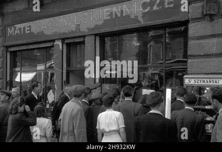 Warszawa, 1947-05-27. Komisja Specjalna do Walki z Nadu¿yciami i Szkodnittem Gospodarczym prowadzi³a dzia³ania przeciwko prywatnym przedsiêbiorcom i w³aœcicielom zwan¹ bitw¹ o handel. NZ. Przechodnie czytaj¹ informacjê o ukaraniu w³aœciciela sklepu w³ókienniczego przy ul. Marsza³kowskiej 99 za spekulacjê. ps/ms PAP Varsavia, 27 maggio 1947. La commissione speciale per la lotta contro le frodi e gli utili ha scatenato una guerra contro gli imprenditori e i proprietari privati chiamata guerra al commercio. Nella foto: Passanti-leggendo un annuncio sulla punizione messa fuori sul proprietario di un negozio tessile a 99 Marsza³kowsk Foto Stock