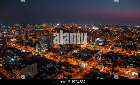 Vista panoramica notturna del drone sul distretto di San Isidro a Lima, Perù Foto Stock