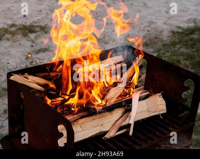 Legna che brucia nella griglia. Piccolo braciere pieghevole portatile  riempito di carboni per la cottura di carne, pesce, barbecue. Cucina alla  griglia all'aperto. Molla o Foto stock - Alamy