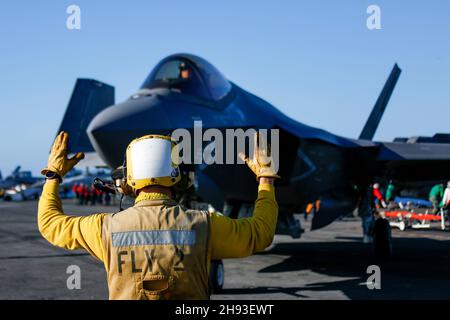 OCEANO PACIFICO (Nov. 8, 2021) Aviation Boatswain's Mate (Handling) Airman Julian Fernando, di Yonkers, N.Y., dirige un F-35C Lightning II, assegnato ai 'Cavalieri neri' di Marine Fighter Attack Squadron (VMFA) 314, sul ponte di volo di USS Abraham Lincoln (CVN 72). Abraham Lincoln sta conducendo le operazioni di routine nella terza flotta degli Stati Uniti. (STATI UNITI Foto Navy di Mass Communication Specialist terza classe Michael Singley/rilasciato) Foto Stock