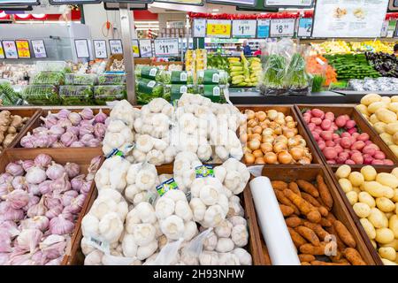 Verdure fresche aglio, patate, cipolle in mostra in un supermercato australiano, Sydney, Australia Foto Stock