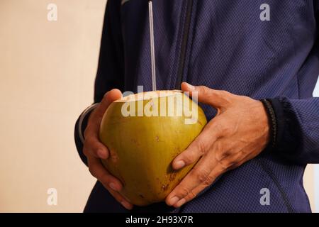 dengue acqua di cocco in una mano paziente Foto Stock