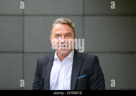 Ritratto laterale di un serio bell'uomo di mezza età che fa un volto divertente Foto Stock