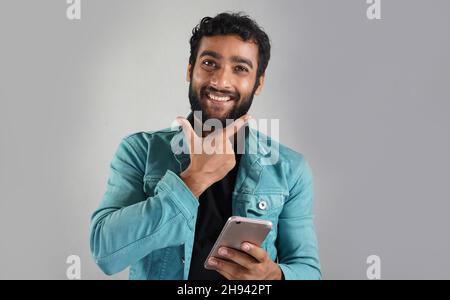 uomo con il cellulare e dire essere sorridente Foto Stock