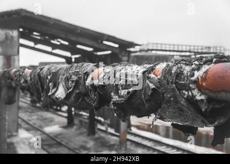 Vecchia pipeline di riscaldamento di tubi usata sporca lacerata in un impianto industriale abbandonato. Foto Stock