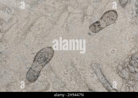 Impronta dalla suola di una scarpa da uomo contro la sabbia. Foto Stock