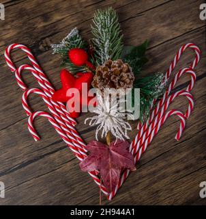 Composizione natalizia con caramelle, stella rossa, cono di pino e rami di abete Foto Stock