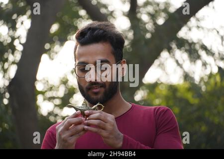 Un ragazzo ha in mano una lampada di Aladdin mentre guardava la lampada Foto Stock