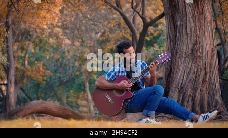 un ragazzo che suona la chitarra Foto Stock