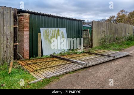 Una recinzione soffiata in un villaggio di Norfolk durante Storm Arwen nel novembre 2021. Foto Stock