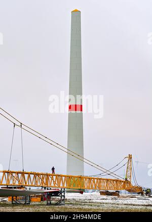 Biegen, Germania. 4 dicembre 2021. Un cantiere per la costruzione di nuove turbine eoliche nel distretto di Oder-Spree nel Brandeburgo orientale (vista aerea del drone). Lo stato di Brandeburgo si colloca al secondo posto tra gli stati tedeschi con la maggiore capacità installata di turbine eoliche. Così, un buon terzo della domanda di elettricità è generato dal vento. Con oltre 7,400 megawatt (MW) di capacità totale installata, il Brandeburgo si colloca al secondo posto dopo la bassa Sassonia. Credit: Patrick Pleul/dpa-Zentralbild/ZB/dpa/Alamy Live News Foto Stock