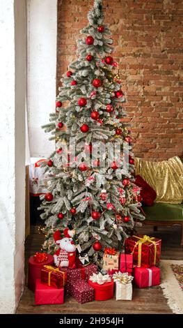Immagine di un albero di Natale decorato nell'angolo della stanza e scatole con regali Foto Stock