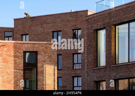 Pulitore di finestra al lavoro (abbeiler, nuovi appartamenti alti, edificio di uffici, sicurezza) - Hudson Quarter, York City Centre, North Yorkshire, Inghilterra UK. Foto Stock